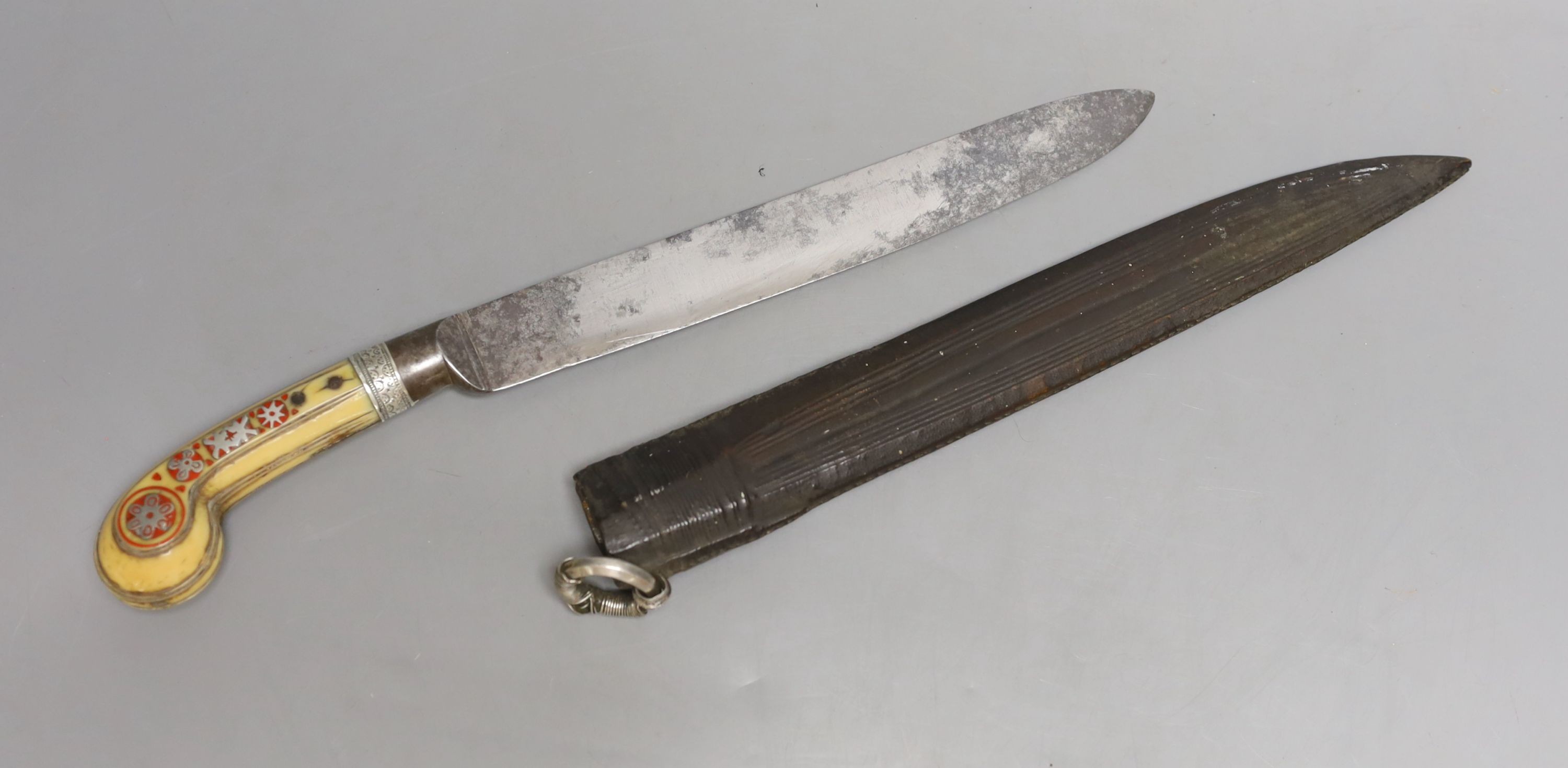 An African Arab knife, 19th century, carved ivory handle with silver inlays, leather covered wood sheath with silver ring, signed European blade 23cms.